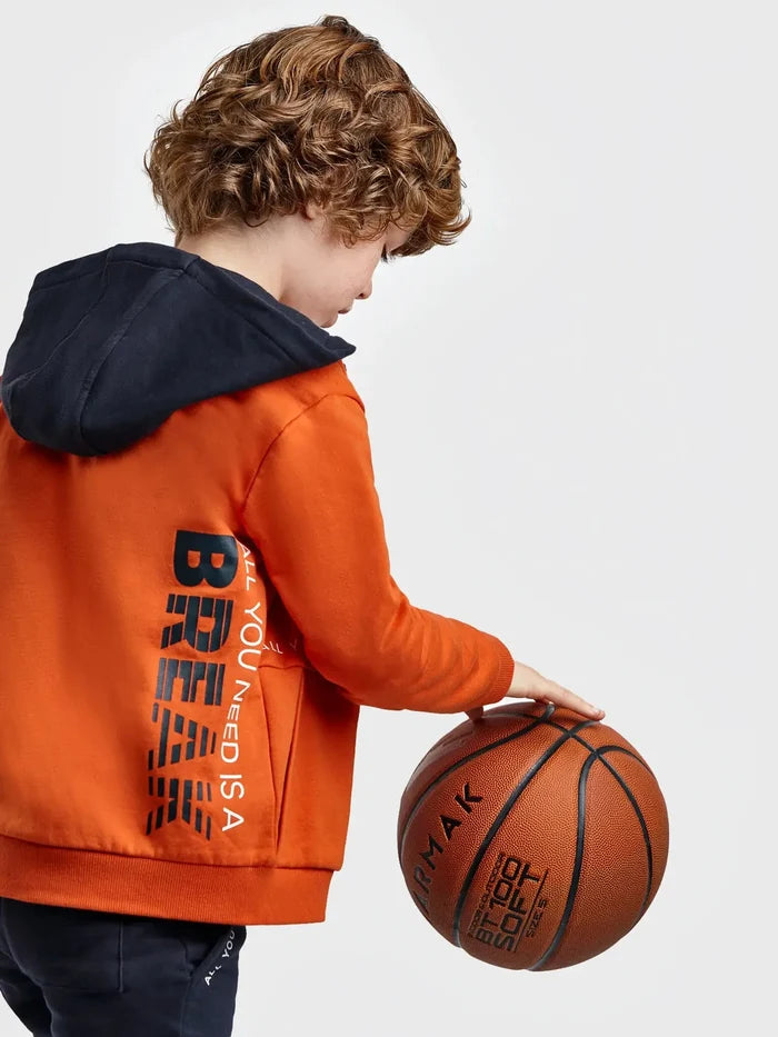 Child wearing the Oxido orange Mayoral tracksuit hoodie, back view with graphic lettering
