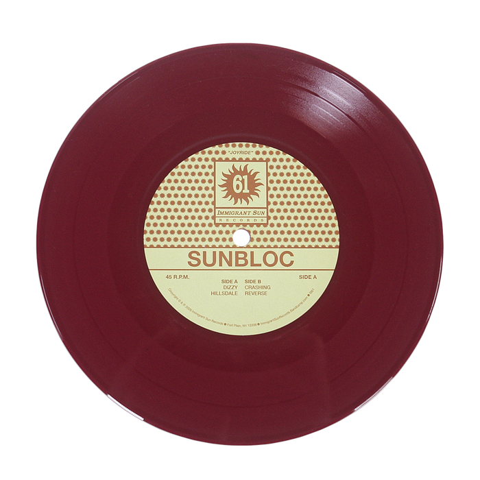 A maroon vinyl record with a cream and brown center label displays Sunbloc and track titles. Ideal for hardcore and alternative fans, the label features a sun logo with IMMIGRANT SUN RECORDS at the top. Brand: Sunbloc.