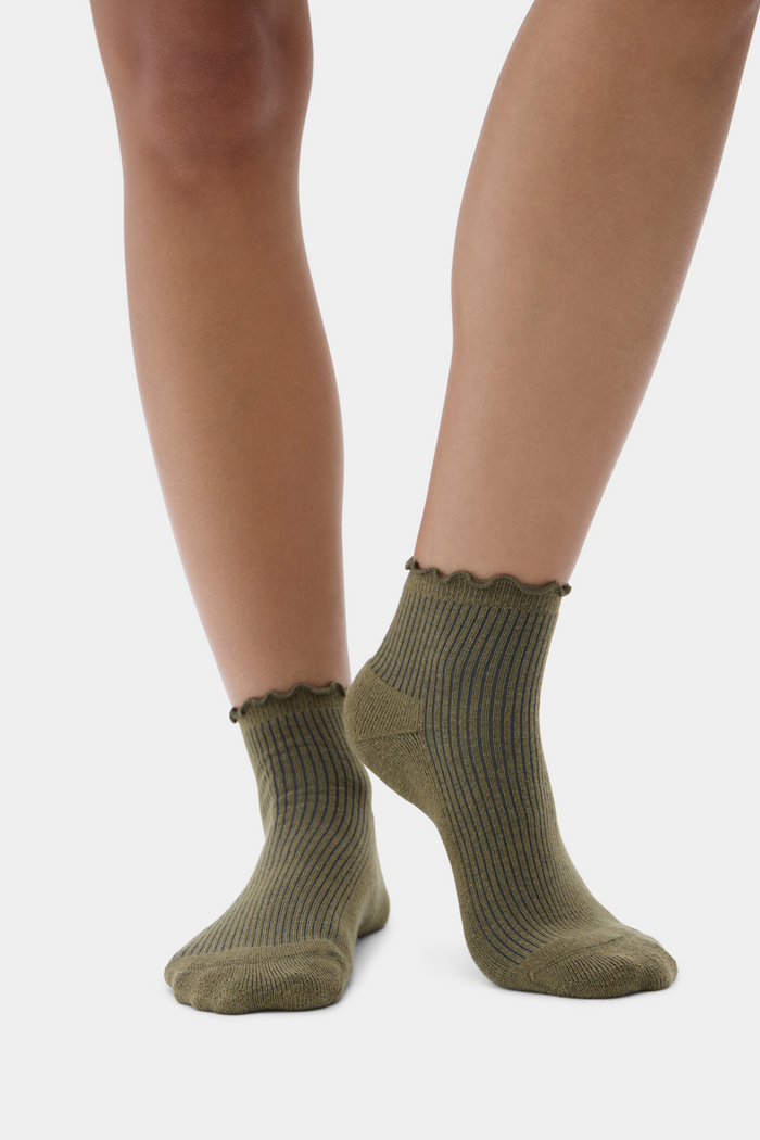 Green socks worn by a person on a white background