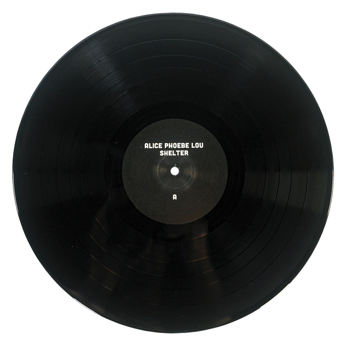 A black vinyl record of Alice Phoebe Lou’s fifth studio album, Shelter, featuring a center label marked with the letter A, is shown against a white background.