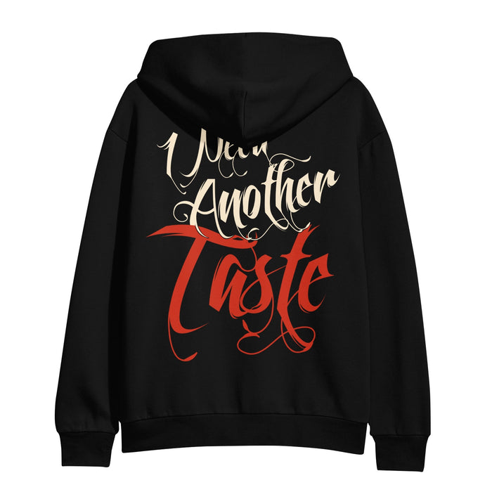 The Melrose Avenue Black Pullover hoodie features “Need Another Taste” in ornate script—“Need Another” in white and “Taste” bold red—on the back. A standout statement piece for any wardrobe.