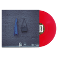 A glossy red Kaonashi vinyl record partially slides out of its album cover, which features a blue jacket, a dark bag on a brick wall, and white shoes on the ground against a gray background.